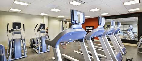 A gym with treadmills, elliptical machines, and weight equipment.