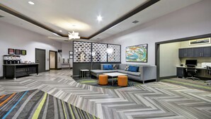 Een moderne hotel lobby met een visgraatvloer, een hoekbank en een koffiehoek.
