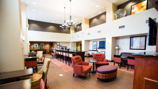 A spacious lobby with multiple seating areas, a reception desk, and artwork on the walls. - Hampton Inn & Suites Blairsville (Blairsville)