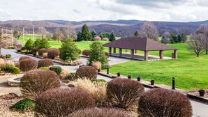 A pavilion in a landscaped area with a view of a green field and distant hills. - Hampton Inn & Suites Blairsville (Blairsville)