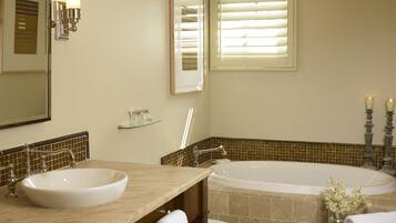 A bathroom with two sinks, a bathtub, and a toilet.