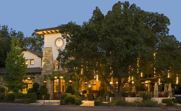 A hotel with a stone tower, a clock, and string lights. - Hotel Cheval (Paso Robles)