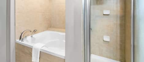 Un baño con bañera y zona de ducha.