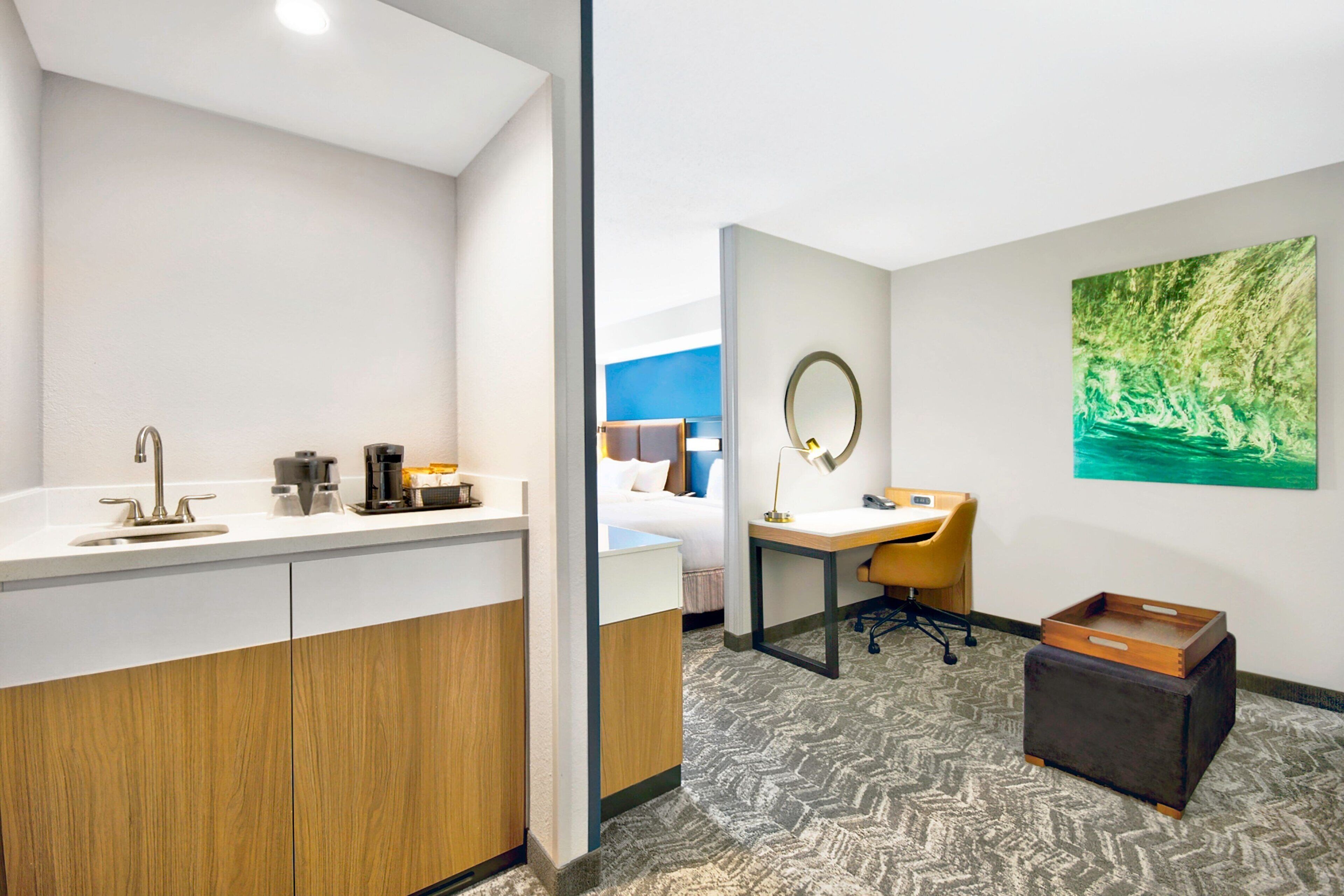 Une chambre d’hôtel moderne équipée d’une salle de bain, d’un bureau et d’un lit.