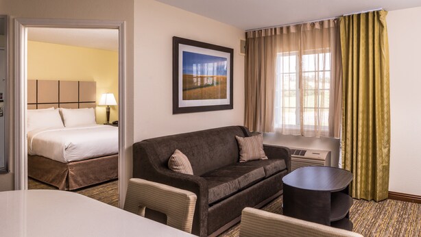 Una habitación de hotel con una cama, un sofá, una mesita y una silla.