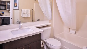 A bathroom with a sink, toilet, and bathtub. - Candlewood Suites Kansas City Speedway by IHG (Kansas City)