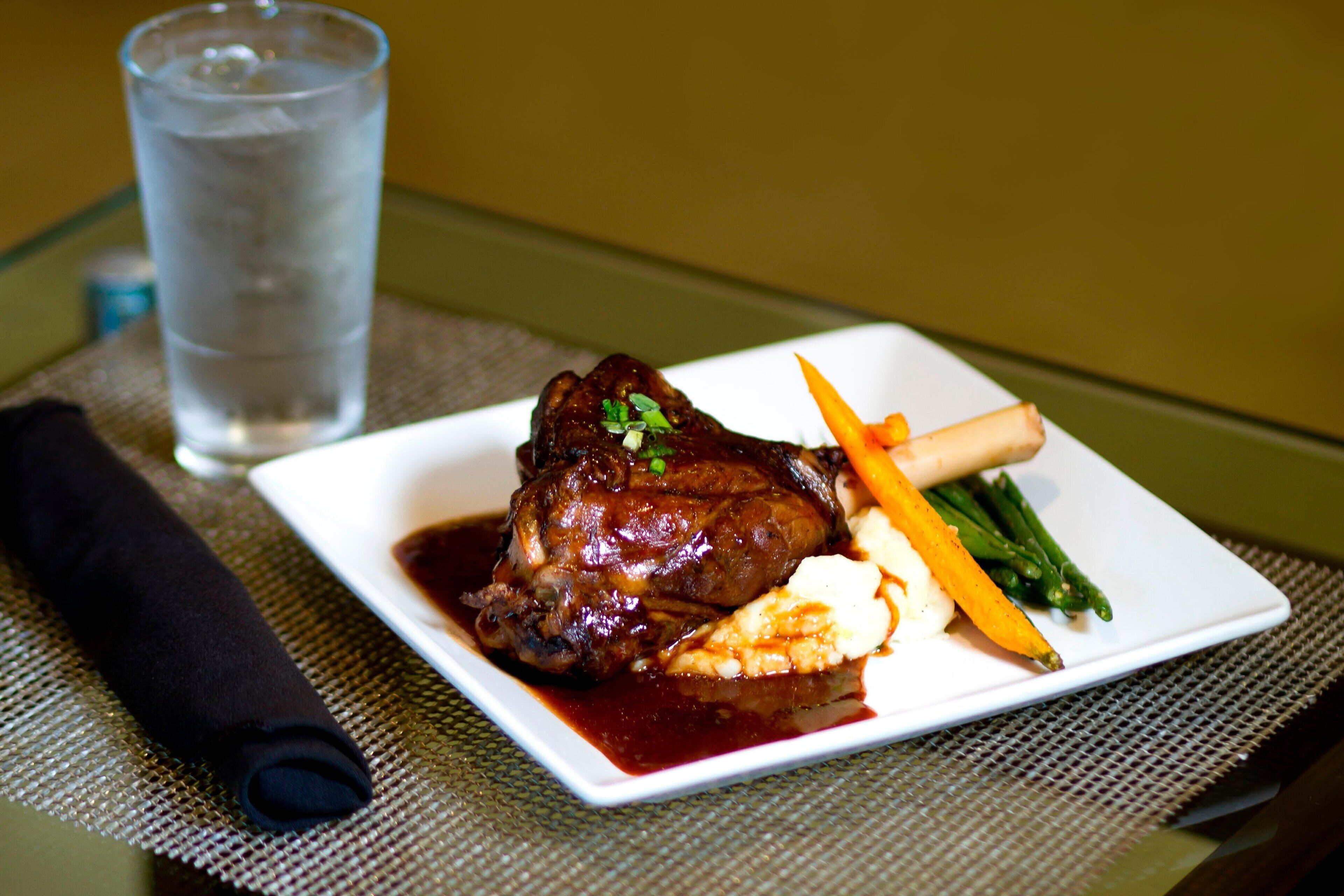 A plate of food with a glass of water on a table.