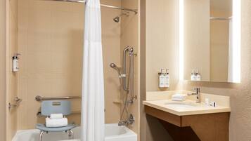 A modern bathroom with a bathtub, shower, and a vanity with a sink and mirror.