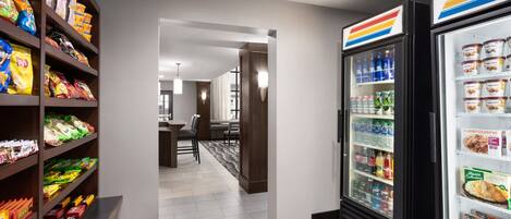 A hotel corridor with snack shelves and a beverage refrigerator.