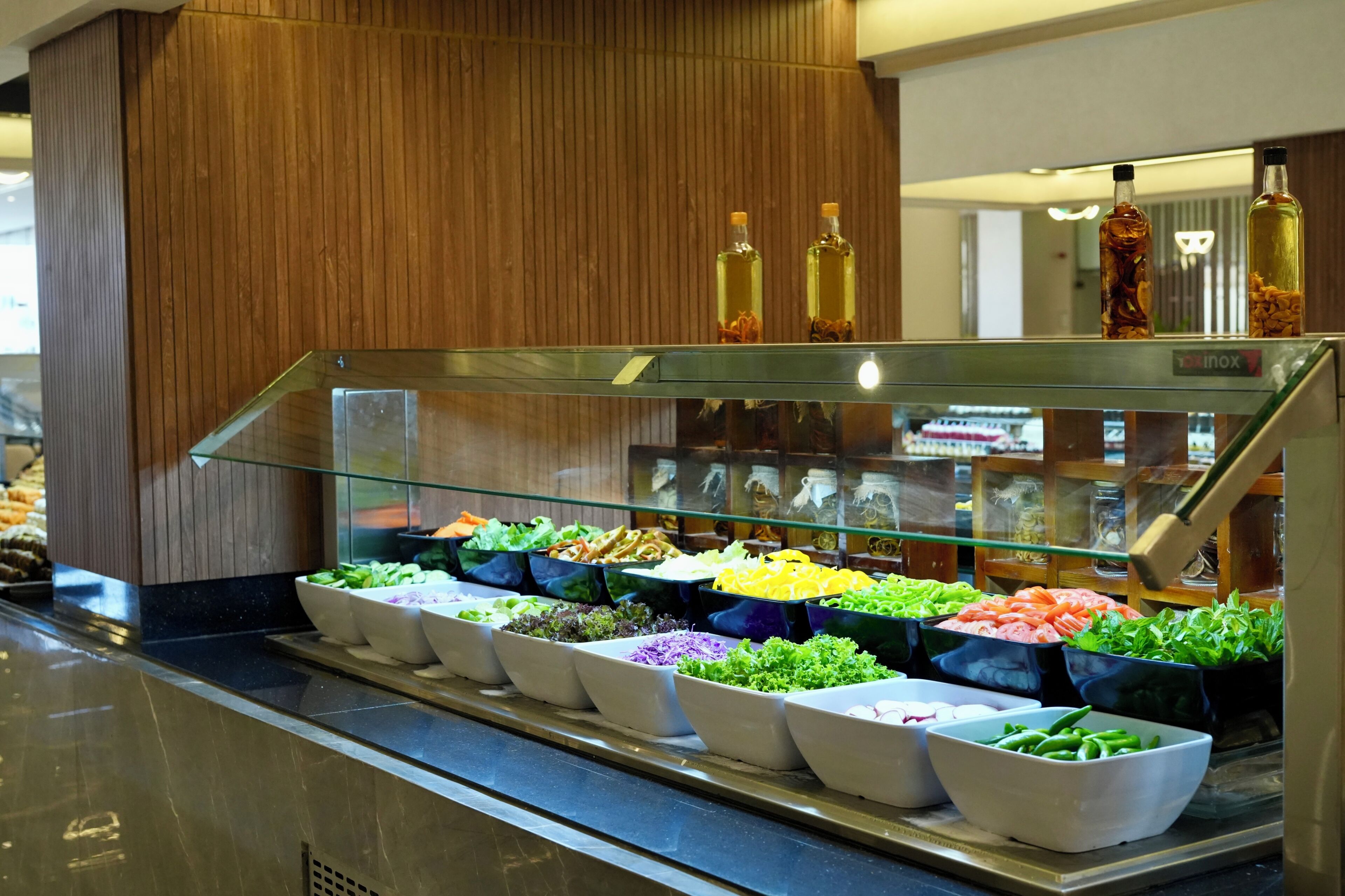 A salad bar with various fresh vegetables and condiments.