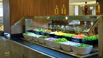 A salad bar with various fresh vegetables and condiments.