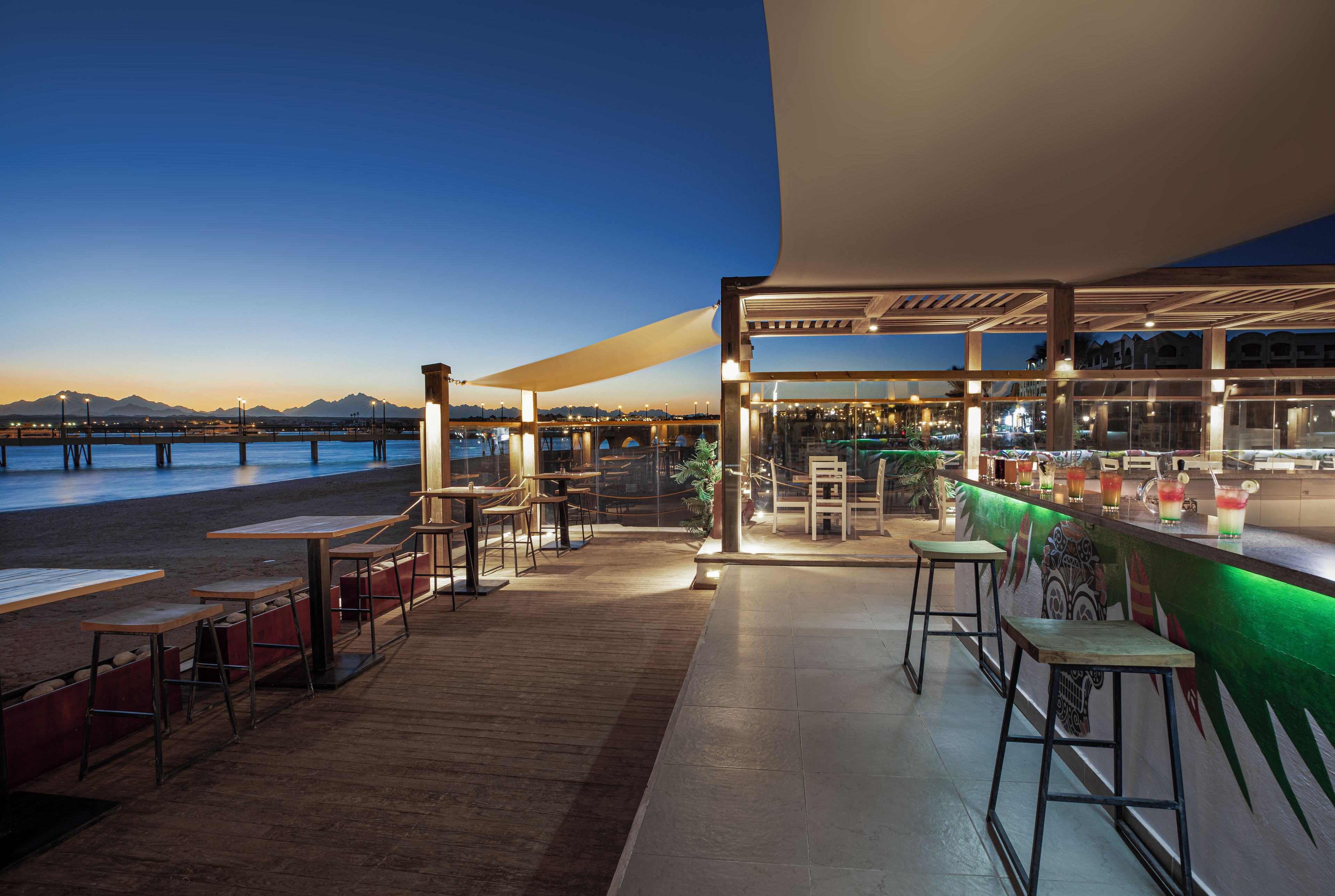 Un restaurante frente al mar con terraza y vistas a la playa y al océano.