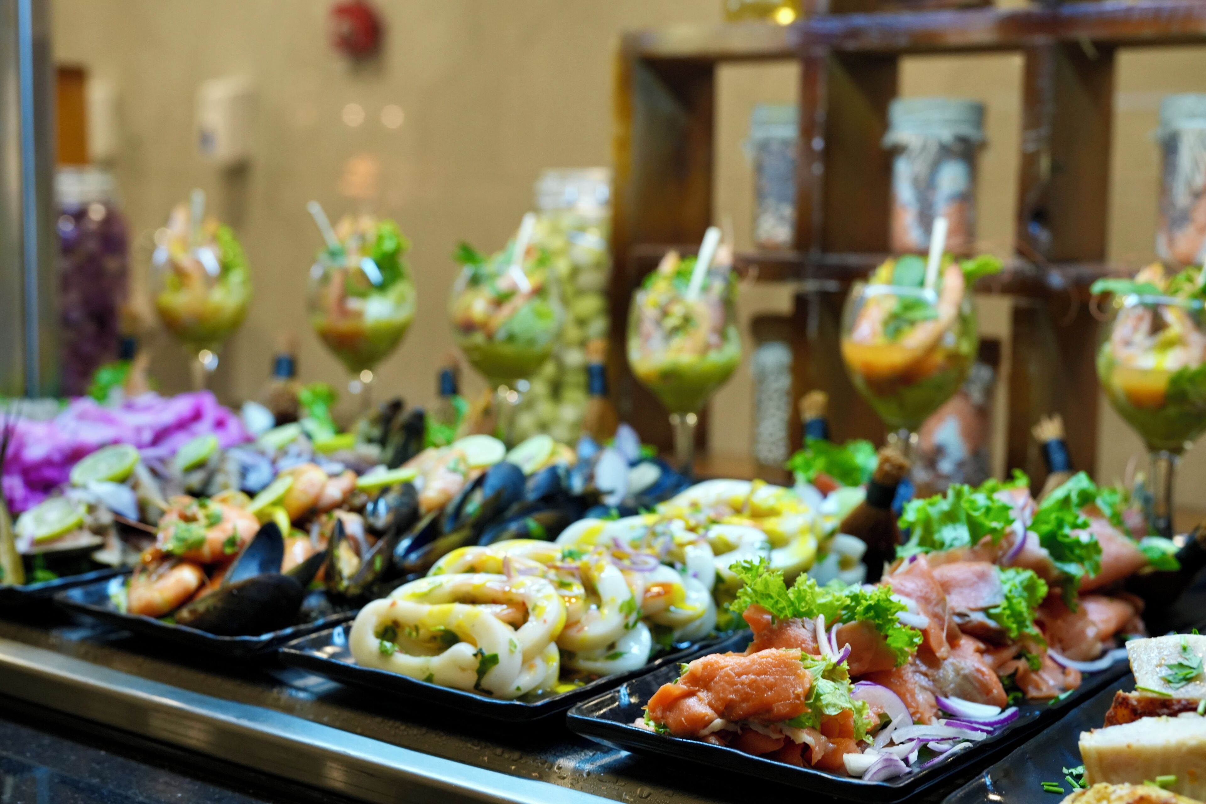Un buffet proposant divers plats de fruits de mer, notamment des moules, des crevettes et un assortiment de salades.