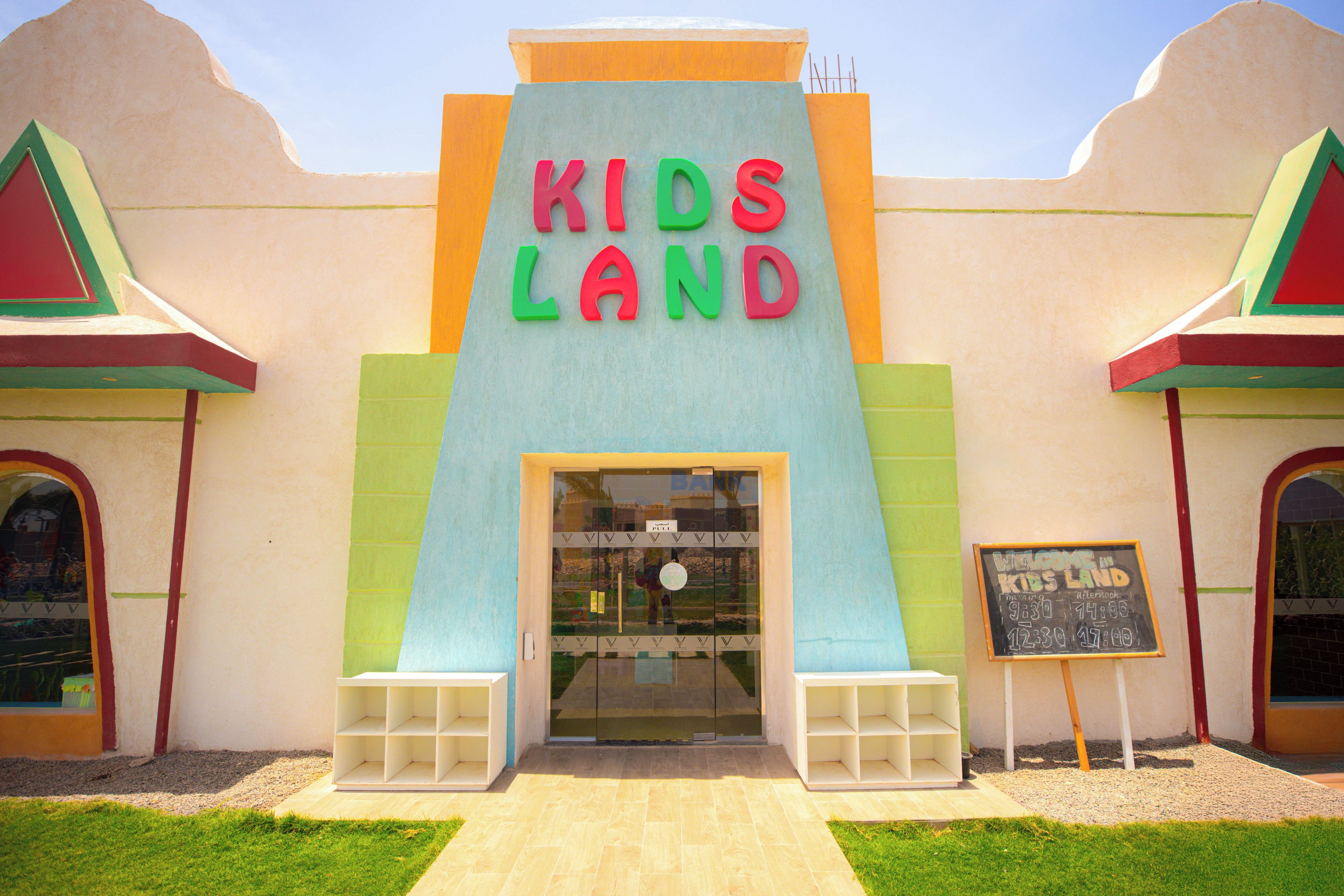 Ein Gebäude mit einem farbenfrohen Schild, auf dem 'KIDS LAND' über dem Eingang zu lesen ist.