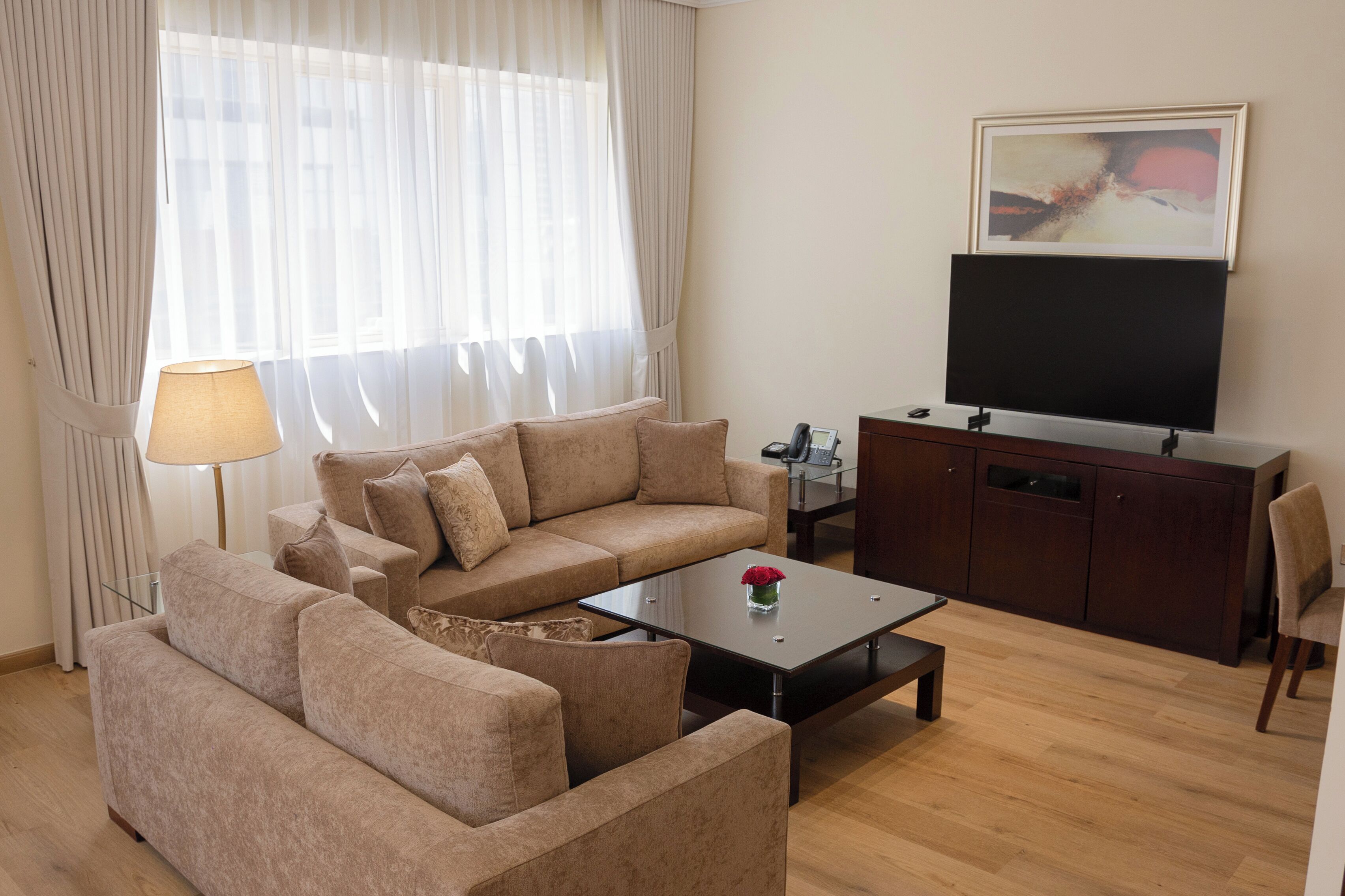 Una sala de estar con un sofá, una mesa de centro, un televisor y un aparador.