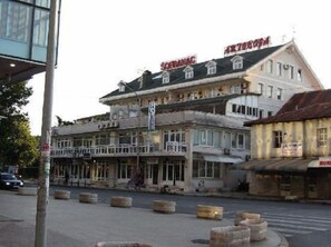 Et hotel med balkon, flere etager og et skilt.