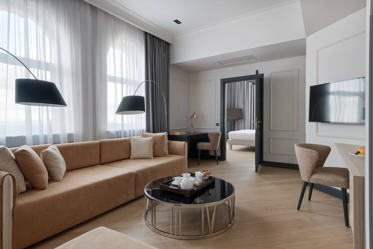 A modern living room with a sofa, coffee table, and dining area.