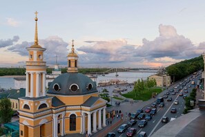A large church with a prominent dome and bell tower, a busy road, and a river in the background.