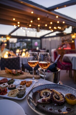 A table set for dining with various dishes and two glasses of wine.