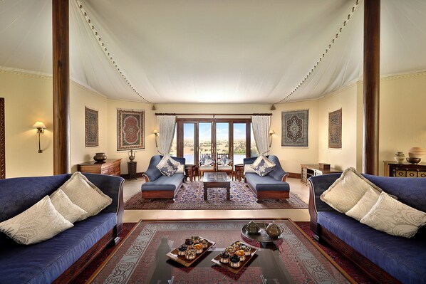A spacious living room with two sofas, a coffee table, and a view through a large window. - Al Maha, A Luxury Collection Desert Resort & Spa, Dubai (Murqquab)