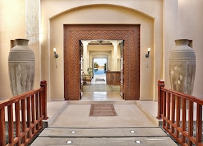 Stunning entrance with ornate woodwork and elegant vases, setting the tone for a sophisticated stay.