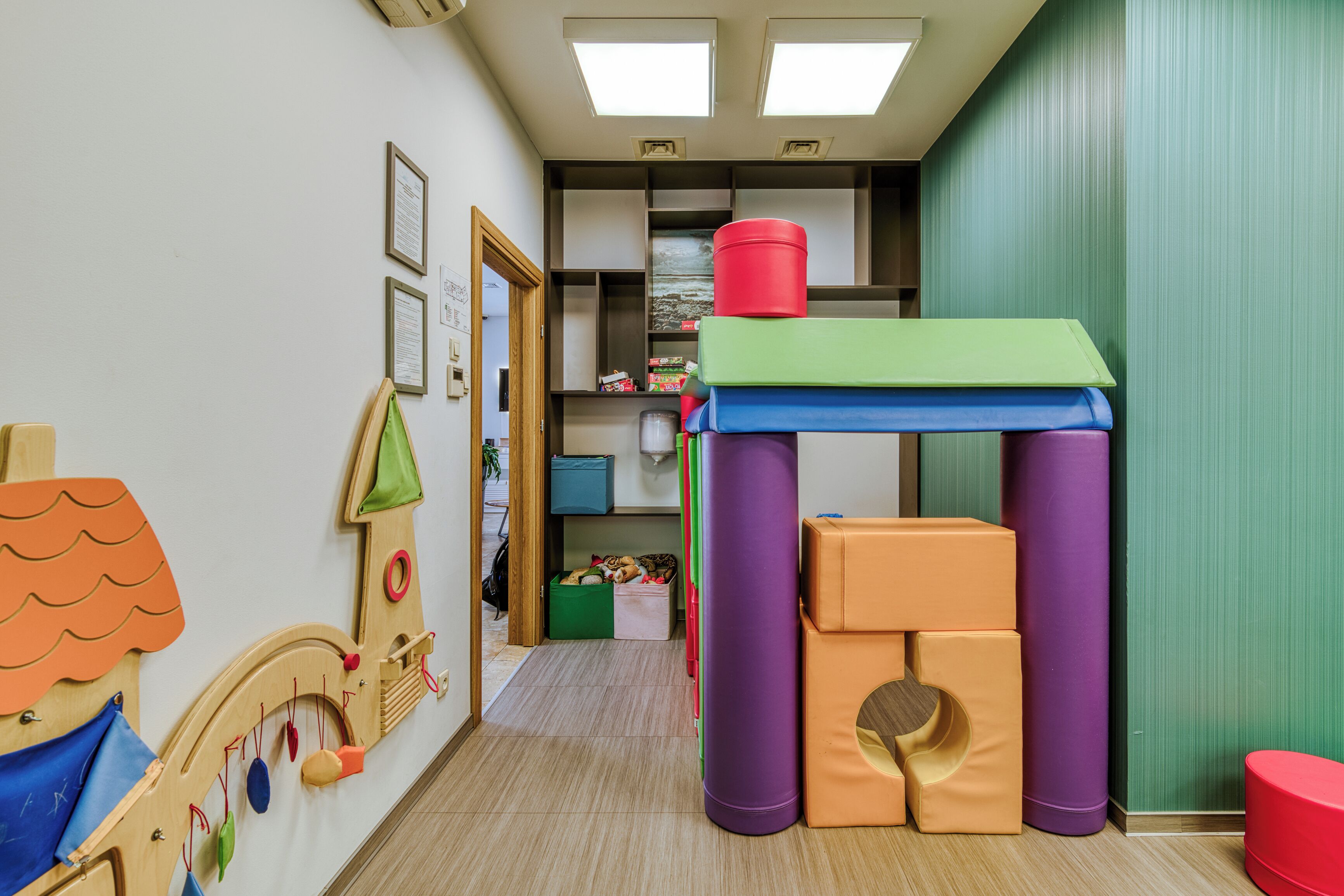 Un área de juegos para niños con juguetes coloridos y una casita.