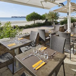 Enjoy a serene seaside dining experience with a clear view of the beach and sea.