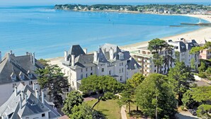 A coastal town with a beach, historic buildings, and a clear blue sea. - Hôtel Vacances Bleues Villa Caroline (La Baule-Escoublac)