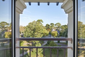 A balcony with a view of a residential area, including houses and trees.