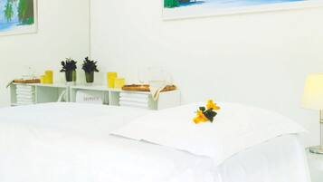 Cozy retreat with a neatly made bed, a small table, and a shelf with decorative items.
