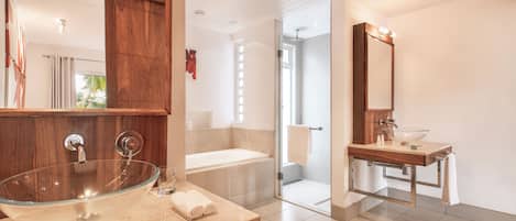 A modern bathroom with a glass vessel sink, a separate vanity, a bathtub, and a walk-in shower.