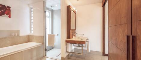 A modern bathroom with a large bathtub, a wooden vanity, and a mirror.