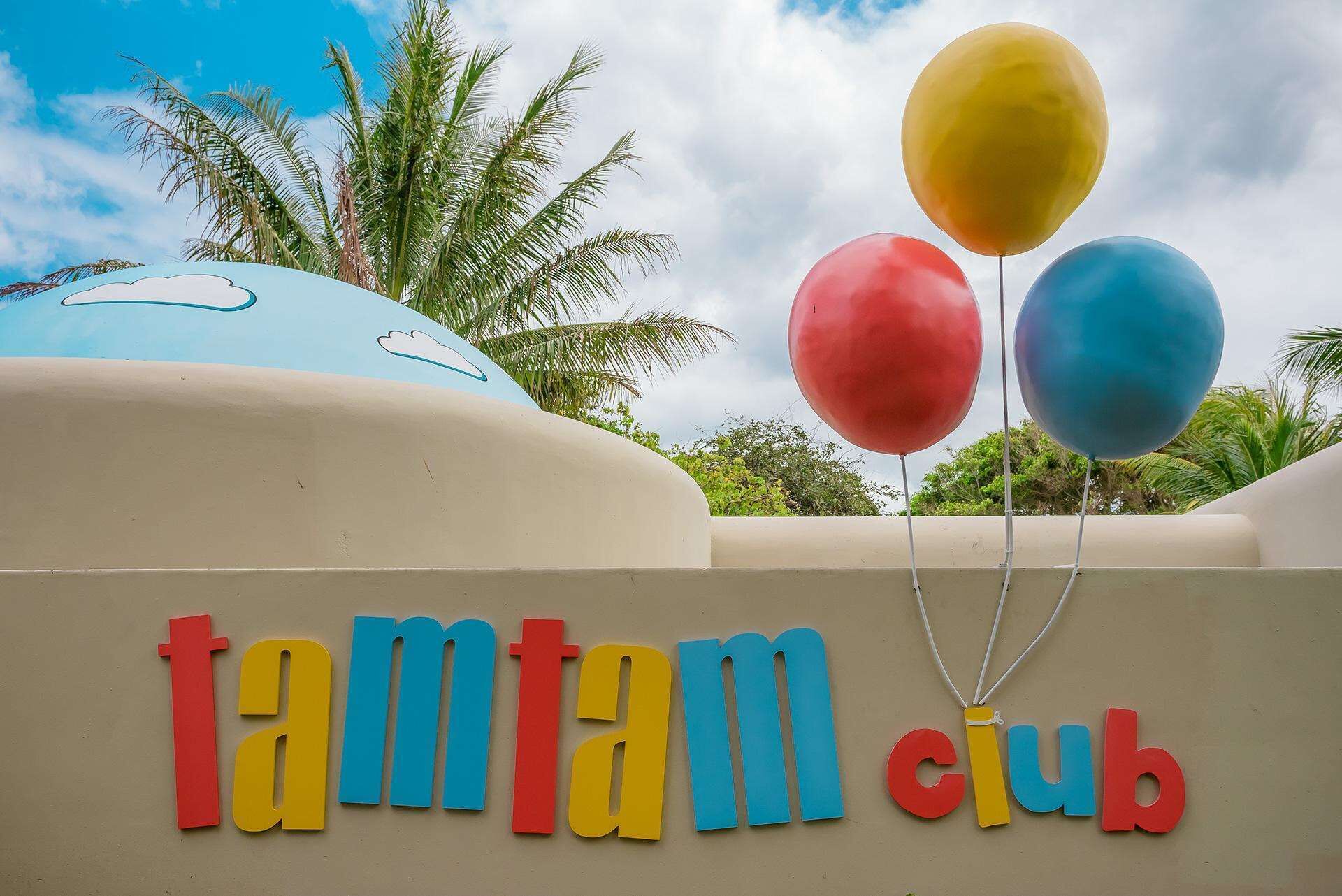 Letrero para 'tamtam club' con letras coloridas y globos.
