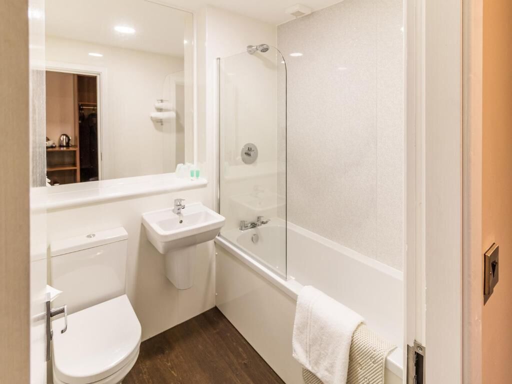 A bathroom with a toilet, sink, and glass-enclosed shower.
