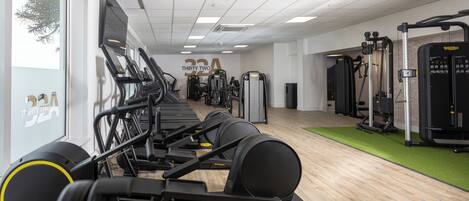 A gym with treadmills, elliptical machines, and weight equipment.