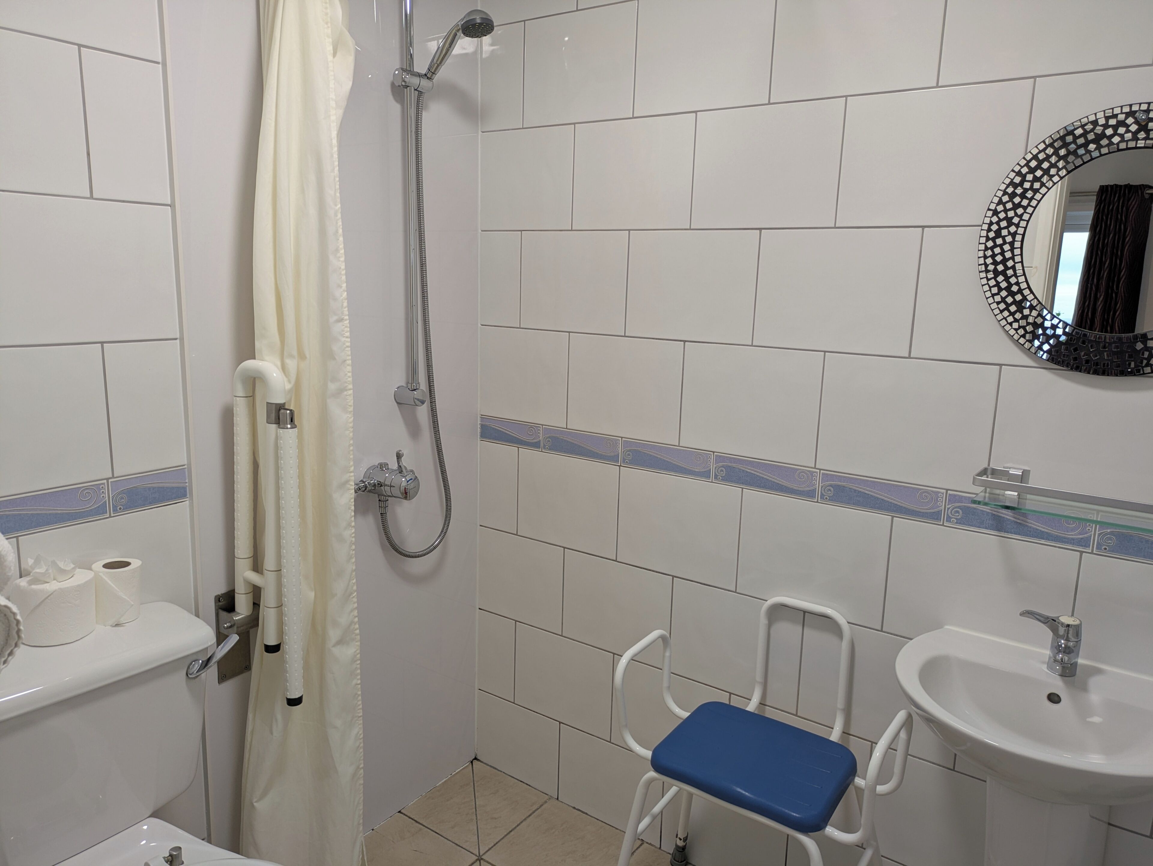 A bathroom with a shower, toilet, and sink.