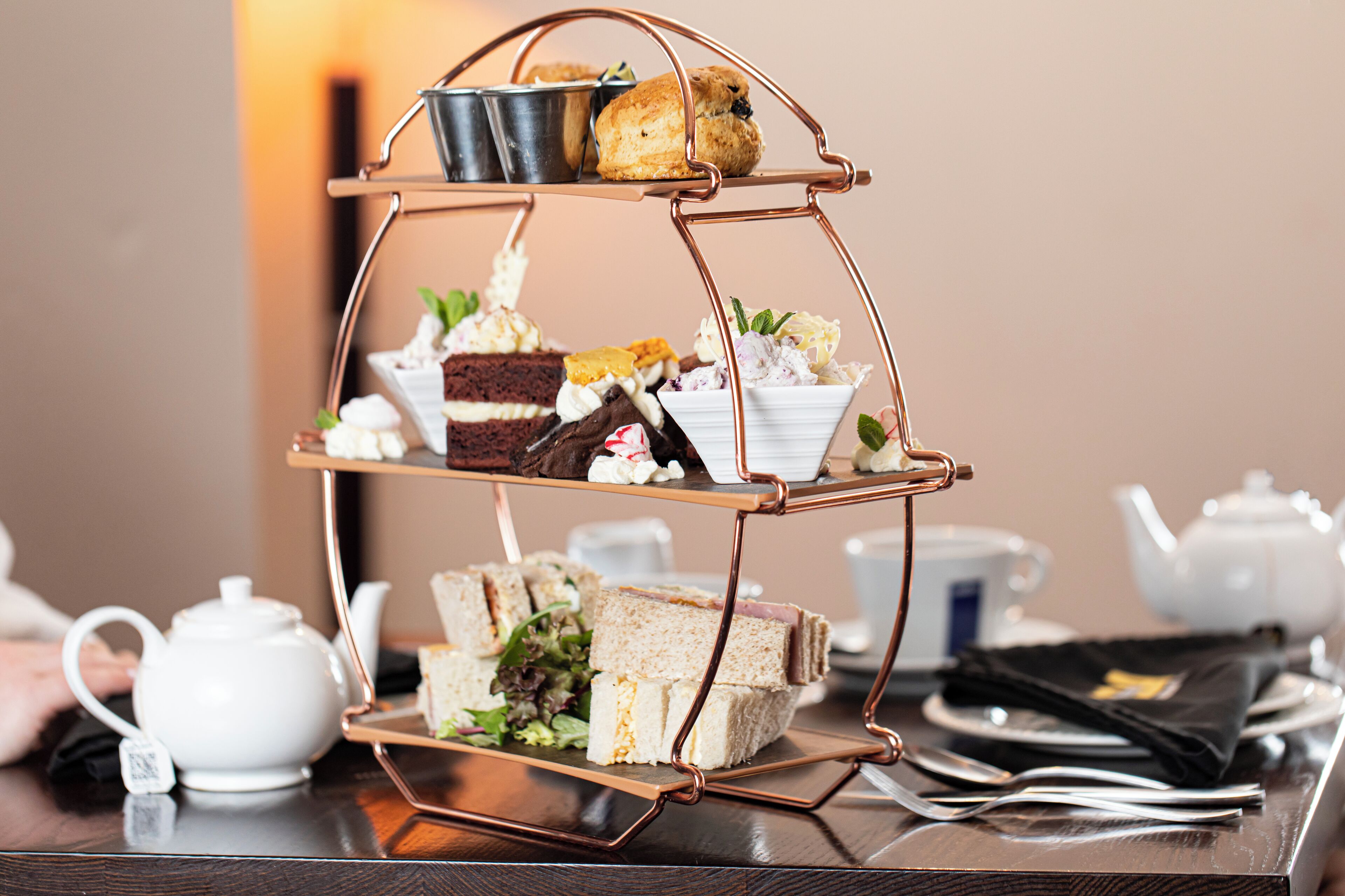 A three-tiered stand with various sandwiches and pastries.