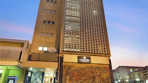 Un hôtel au design moderne, caractérisé par une façade imposante aux motifs originaux et une grande fresque murale.