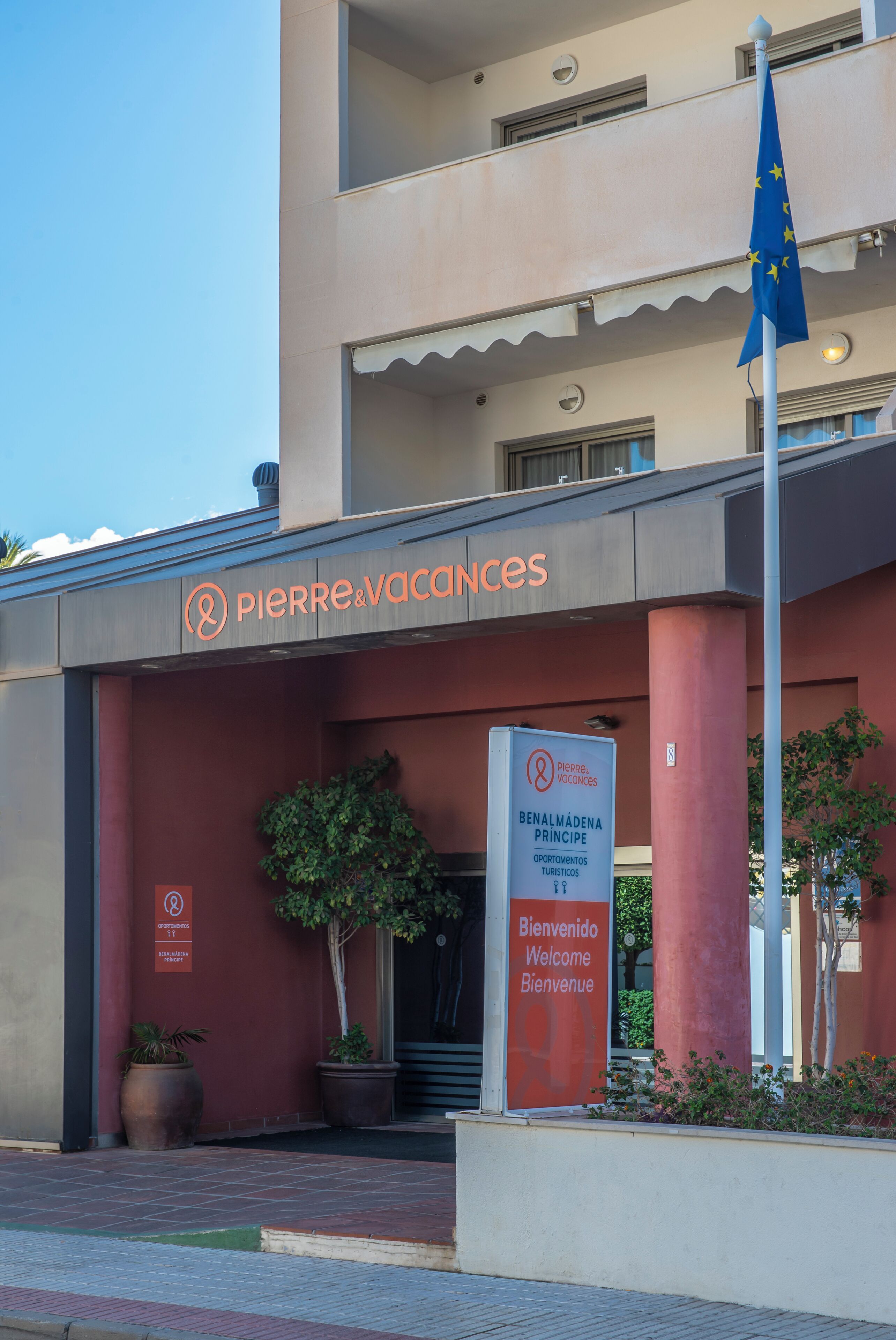 A building with a sign reading "Pierre & Vacances" and a welcome sign in multiple languages.