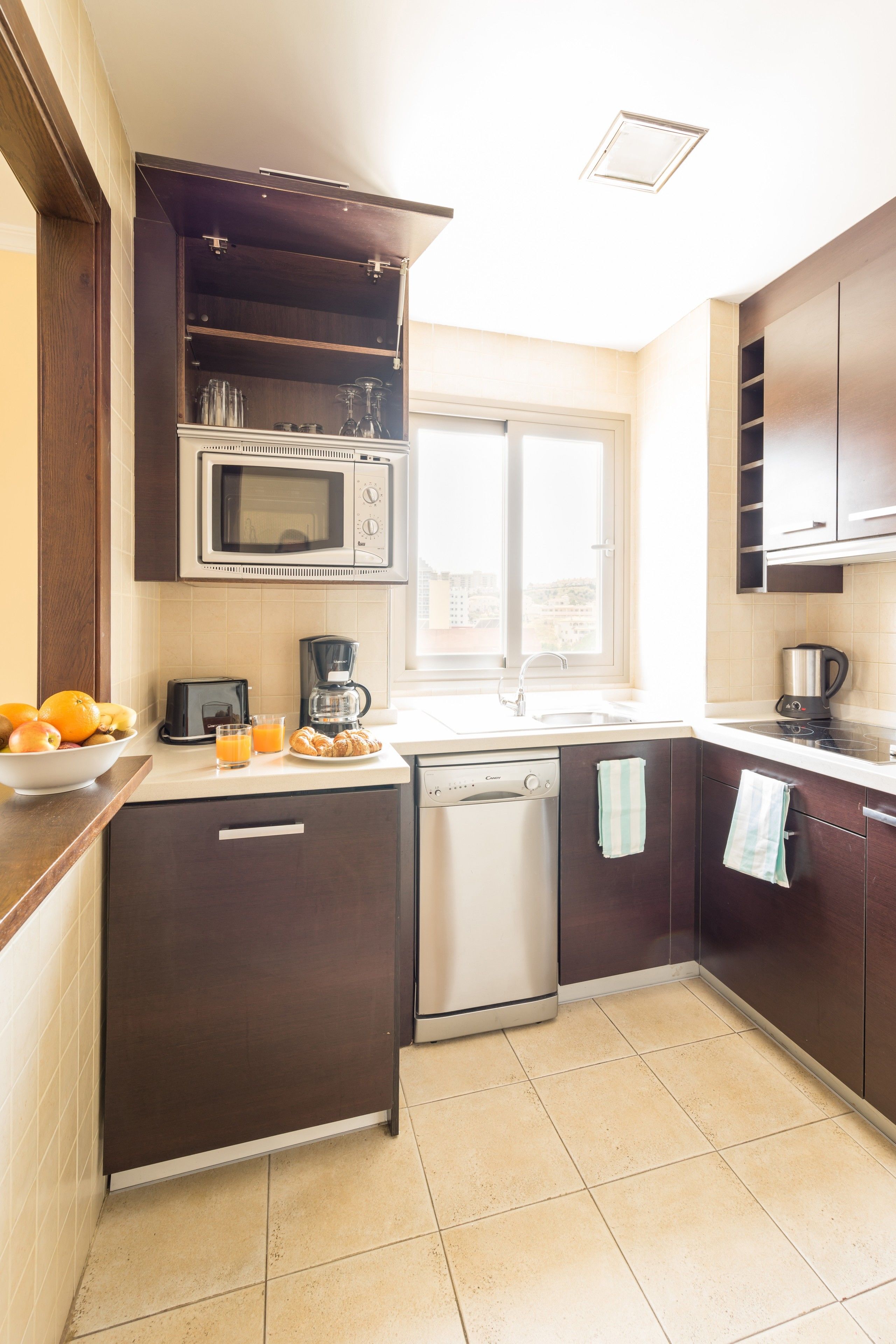 A compact kitchen with a microwave, coffee maker, and dishwasher.