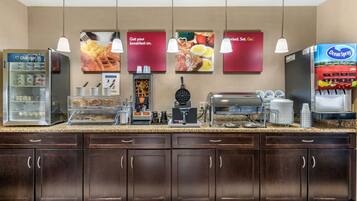Una barra de desayuno con refrigerador, cafetera y dispensador de jugo Ocean Spray.
