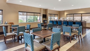 A hotel lobby with multiple seating areas, a reception desk, and large windows providing natural light. - Comfort Suites Elkhart South (Elkhart)