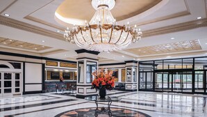 A spacious lobby with a large chandelier, a central floral arrangement, and a geometric floor design. - Horseshoe Tunica Hotel & Casino - A Caesars Rewards Destination (Robinsonville)
