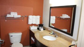 Un baño de hotel con inodoro, lavamanos y toallero.