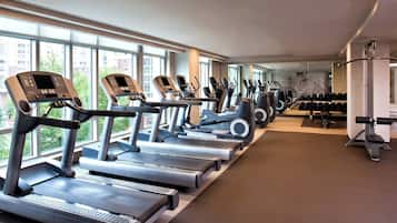 Una palestra con tapis roulant, ellittiche e pesi.