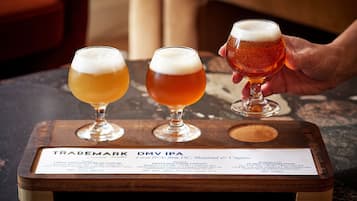 Three glasses of beer on a wooden tray with a label.