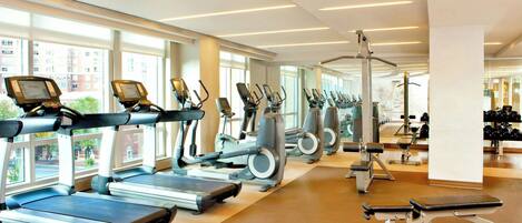 A gym with treadmills, elliptical machines, and weight equipment.