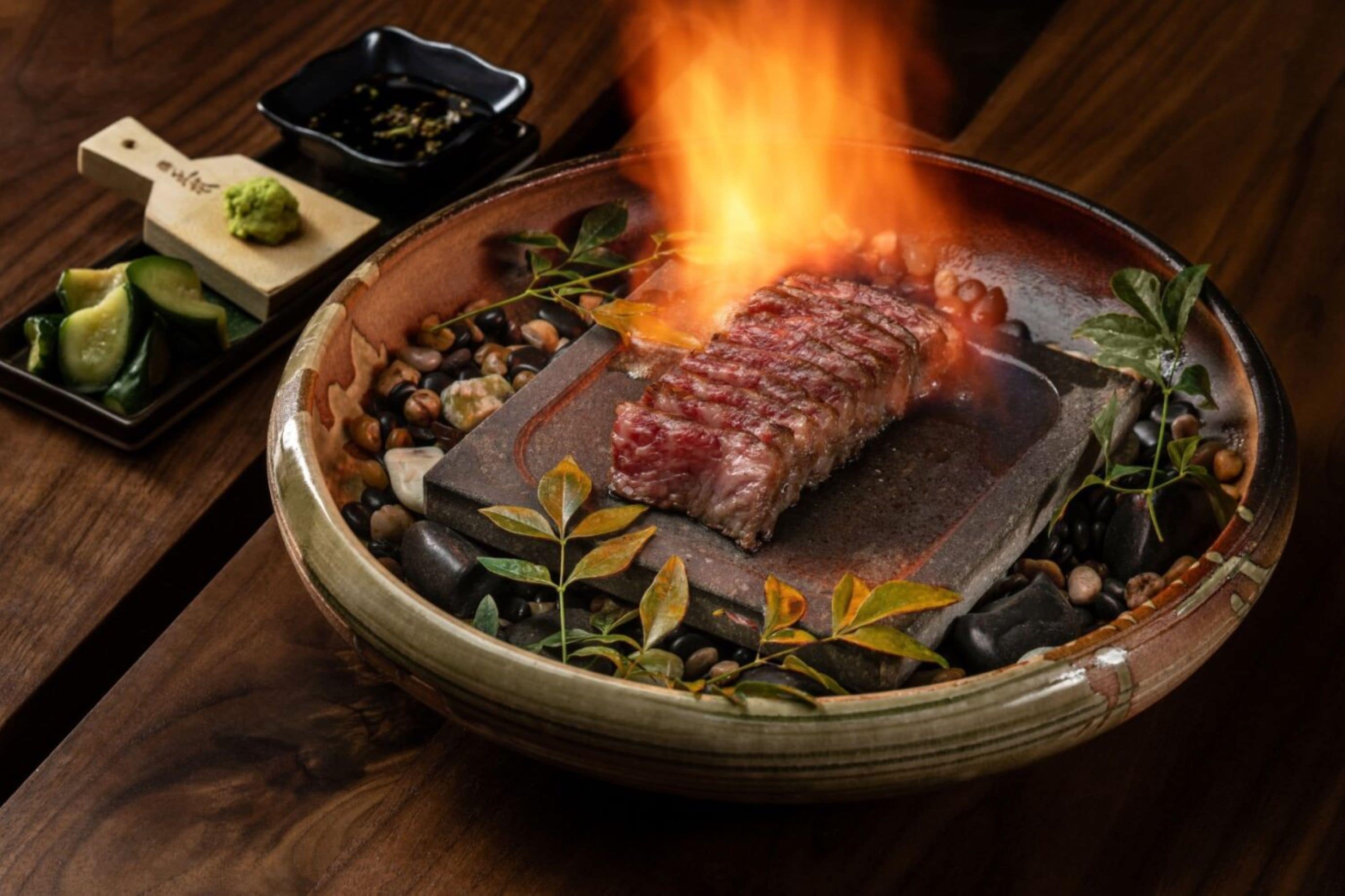 Un filete asado sobre fuego vivo, rodeado de hierbas y especias.