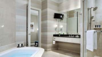 A modern bathroom with a freestanding bathtub, a glass shower enclosure, and a large mirror.