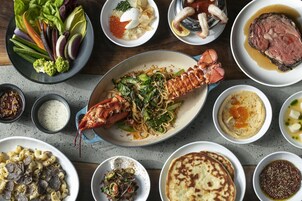 A variety of dishes including a lobster, pasta, and a steak, suggesting a diverse meal selection.